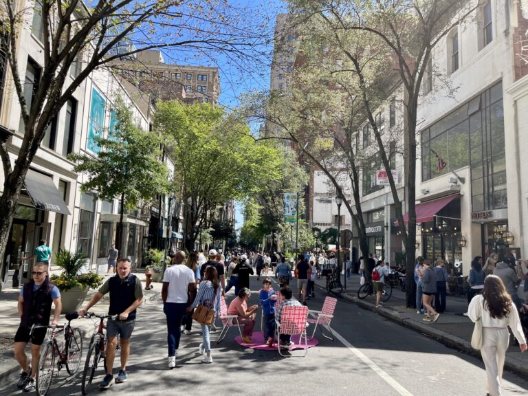 Lots of people walking around on a closed busy street