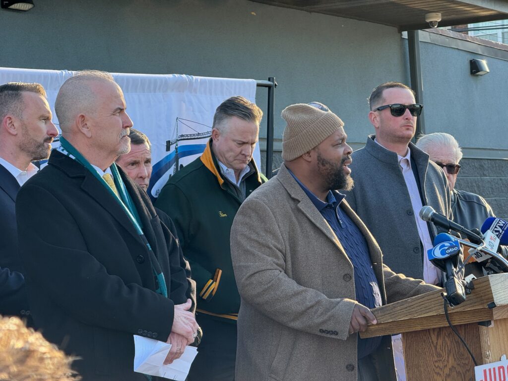Pat Dugan speaks behind a podium