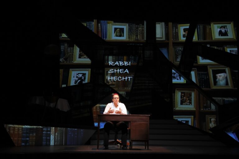 Phyllis Johnson performs onstage at a desk