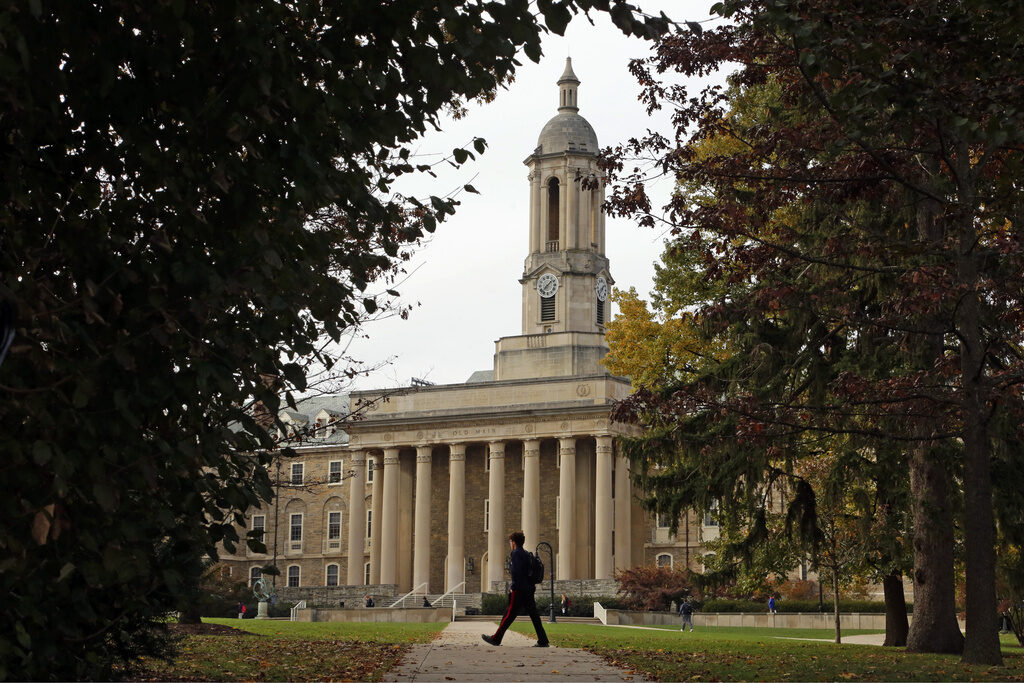 Penn State-Student Newspapers Removed FILE- In this Nov. 9, 2017, file photo people walk by Old Main on the Penn State University main campus in State College, Pa. (AP Photo/Gene J. Puskar, File)