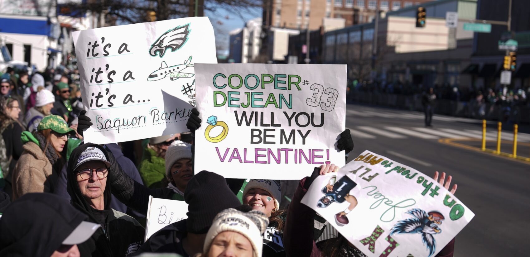 Fans holding up signs along the parade route