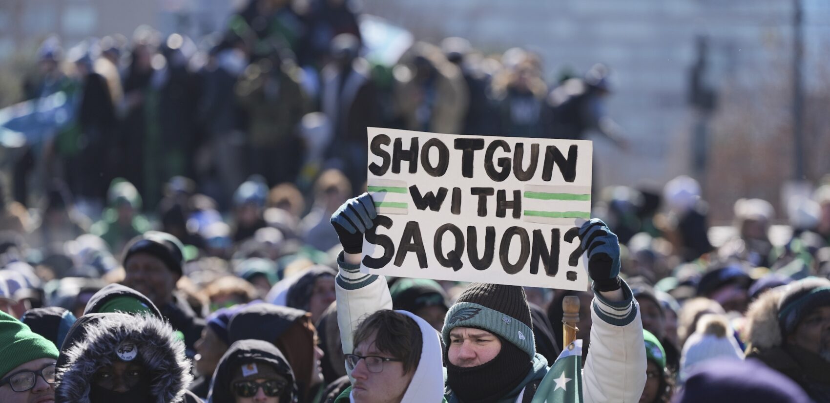 A fan holds up a sign saying 'Shotgun with Saquon?'