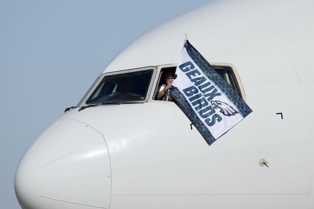 Super Bowl Football A pilot waves a flag out of the cockpit window that says 'Geaux Birds'