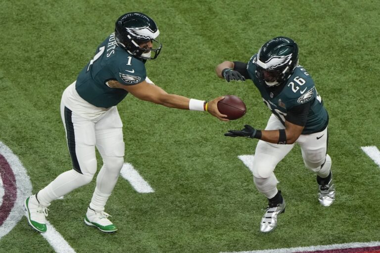 Jalen Hurts handing off to Saquon Barkley