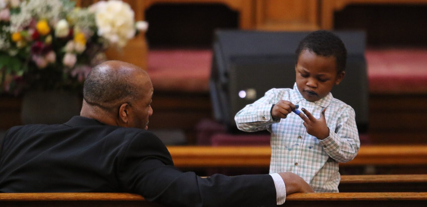 a child and a man in a pew