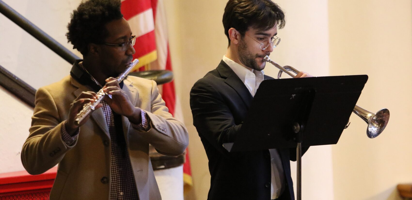 one person plays flute, another plays trumpet