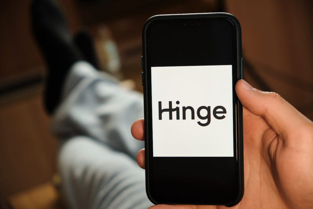 Hinge Logo On The Screen Of Smartphone In Mans Hand Laying On The Sofa. Application For Dating, June A Hinge logo appears on the screen of smartphone. (Bigstock/Vladimka)