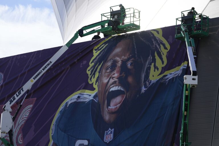 Workers hanging up banners outside the stadium