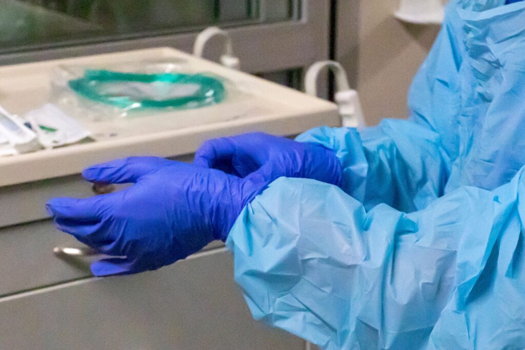 nurse-file-gloves-2021 a nurse's hands adjusting gloves