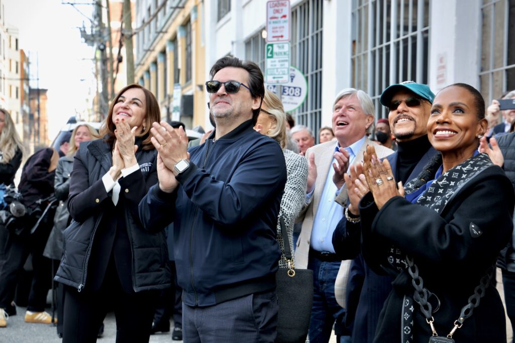 Onlookers applaud as the final girder is laid on the Pennsylvania Ballet's 48,000-square-foot expansion. They include (from left) Executive Director Shelly Power, Artistic Director Angel Corella, Board Chairman David F. Hoffman, Pennsylvania State Sen. Vincent Hughes and his wife, Abbott Elementary star Sheryl Lee Ralph.