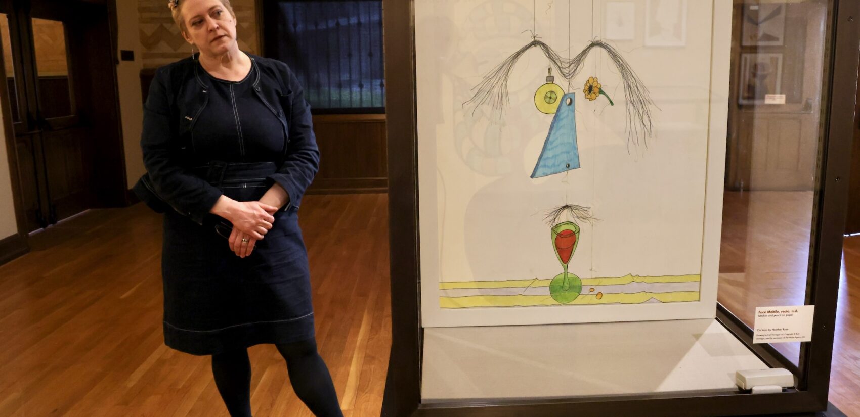 Heather Rose stands next to a drawing