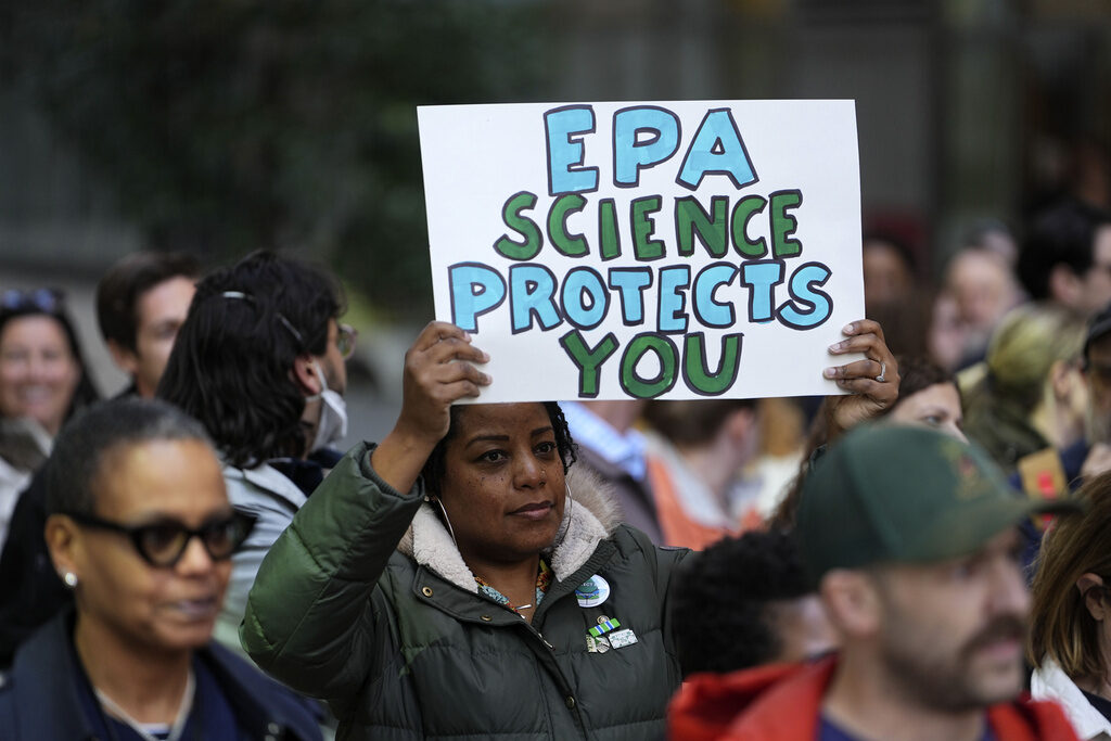 Trump EPA Protests A woman holds a sign in a crowd reading