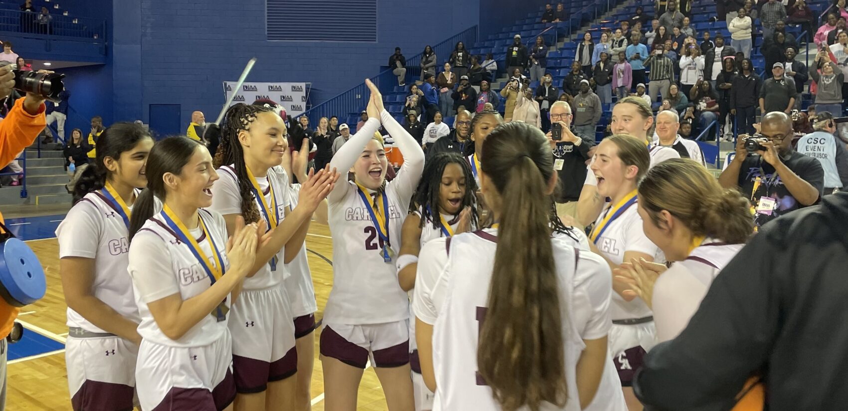 Members of the team celebrate on the court after the game