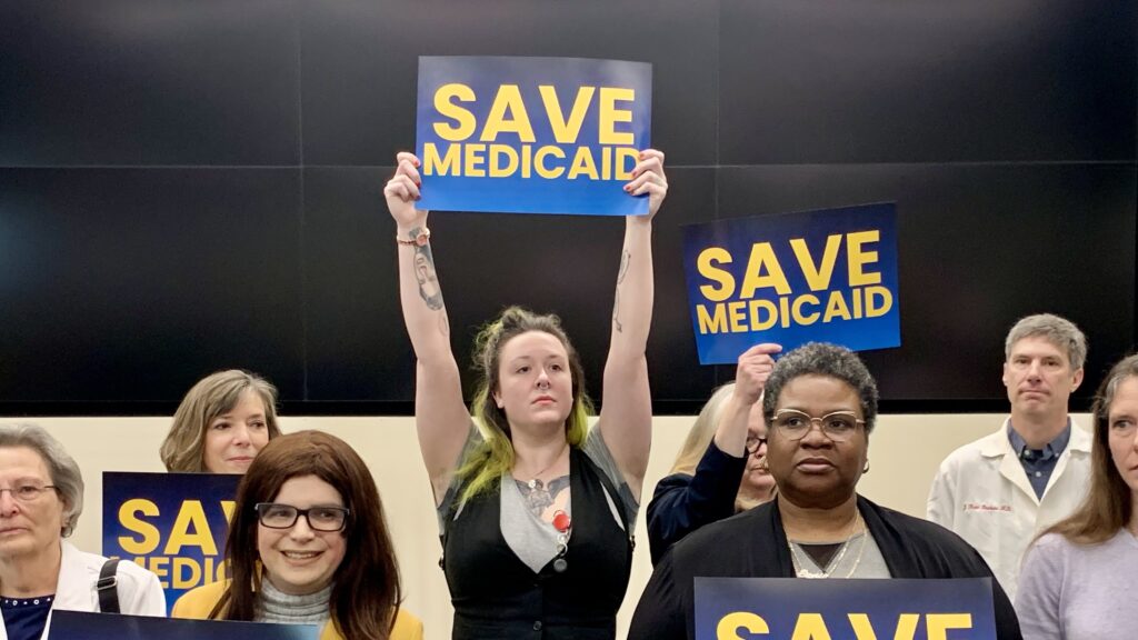 delaware-delegation-s-mueller-2025-03-17-1 People holding up signs that say 'SAVE MEDICAID'