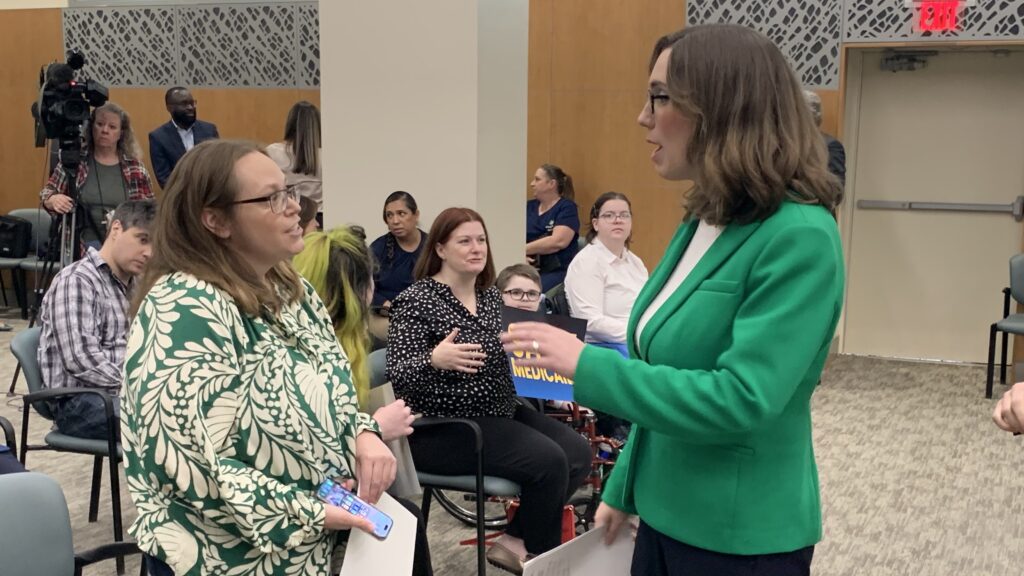 Sarah McBride speaking to someone at the conference