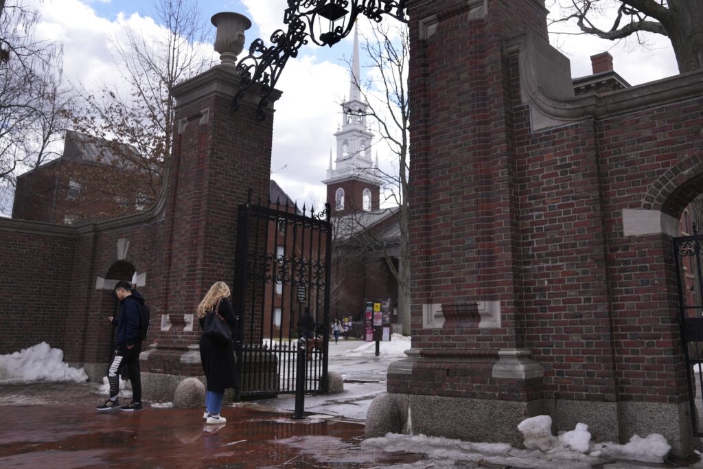 Harvard Pedestrians walk through the gates of Harvard Yard at Harvard University