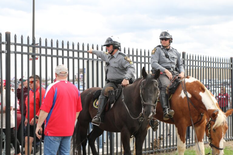 Two police officers on horses direct traffic at the stadium