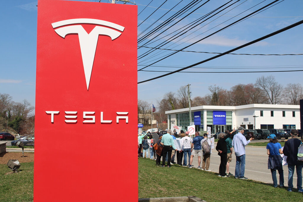 People protest a Tesla car dealership in Chester County