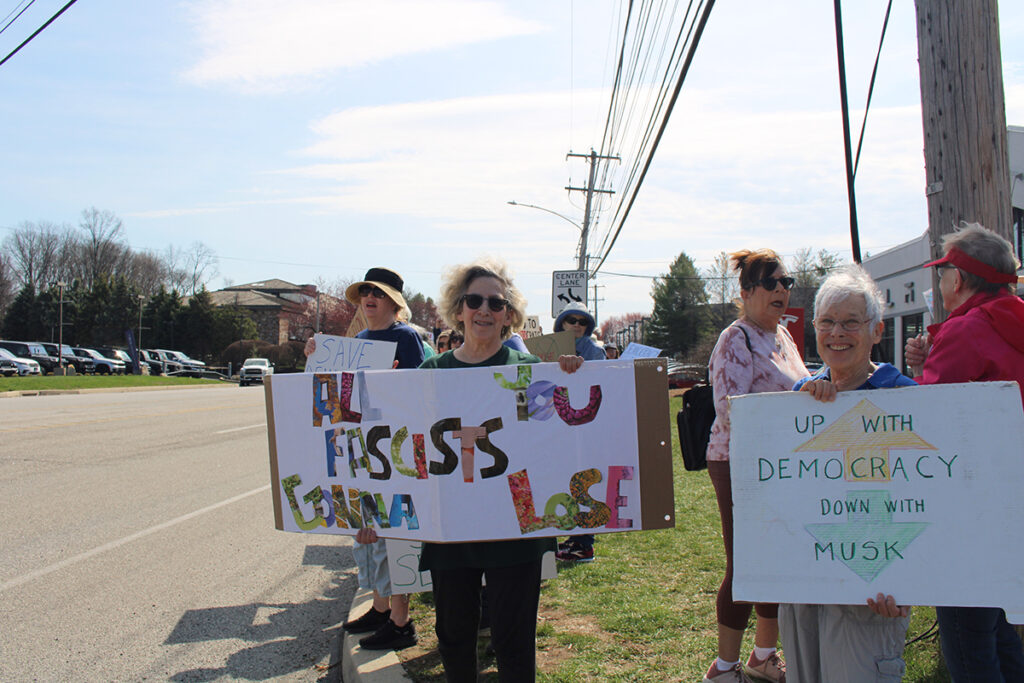 People protest a Tesla car dealership in Chester County