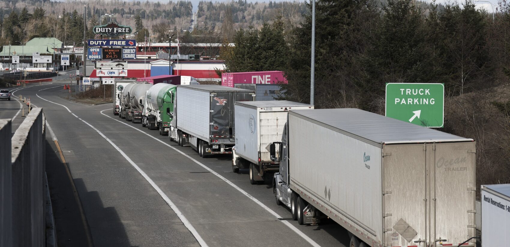 Trucks lined up entering a parking lot at the border