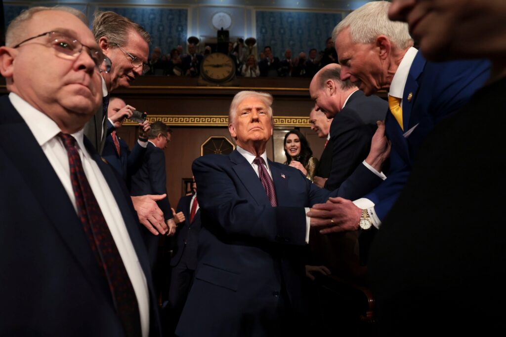 President Trump Delivers First Address To Joint Session Of Congress Trump shakes hands with people as he enters the senate floor