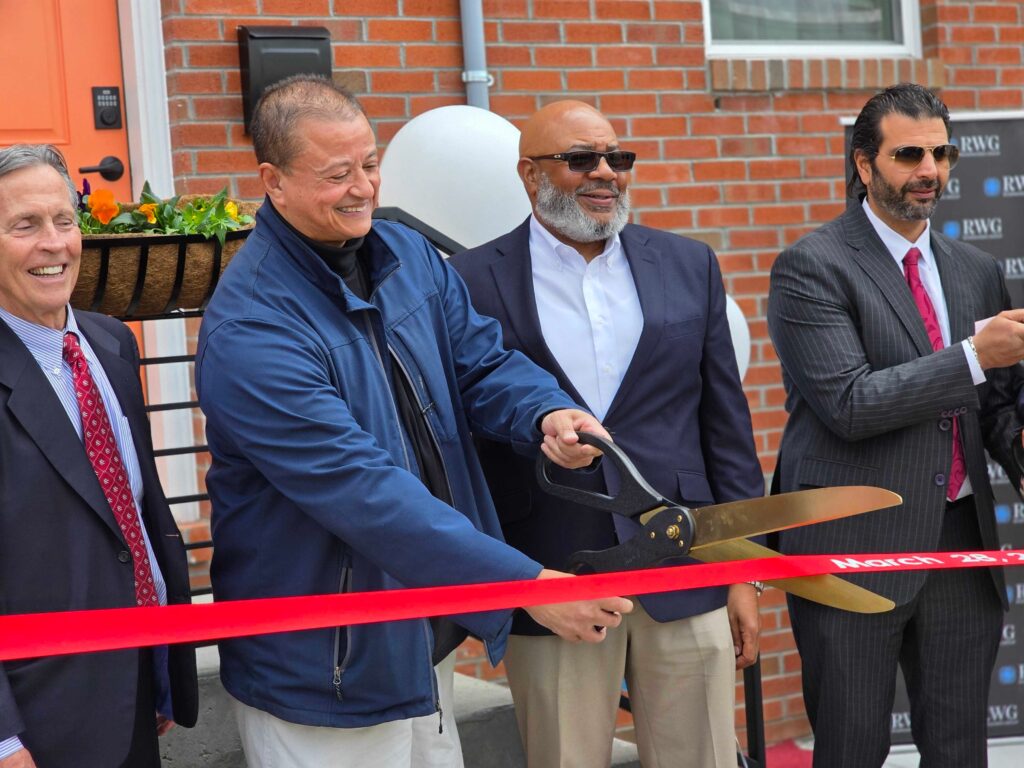 Four people cutting a ribbon