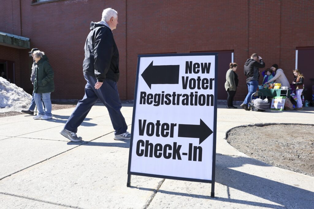 A sign at a polling place indicating where to vote and where to register