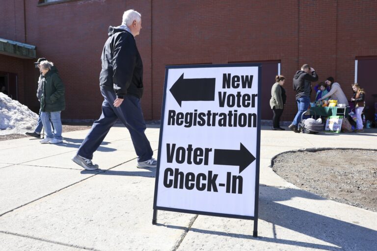 A sign at a polling place indicating where to vote and where to register