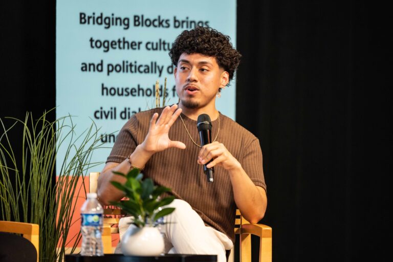 Johnny Perez-Gonzalez speaking on stage during a panel discussion