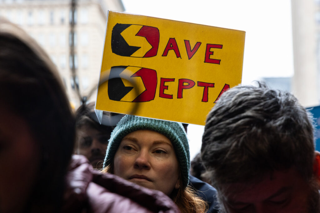 the face of a protester with a sign reading SAVE SEPTA