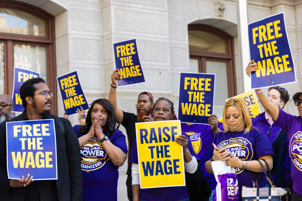 Union members at the rally holding signs saying "Raise the wage."