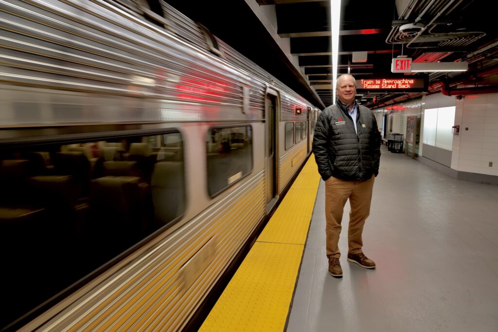 John Rink standing on the platform as a train goes by