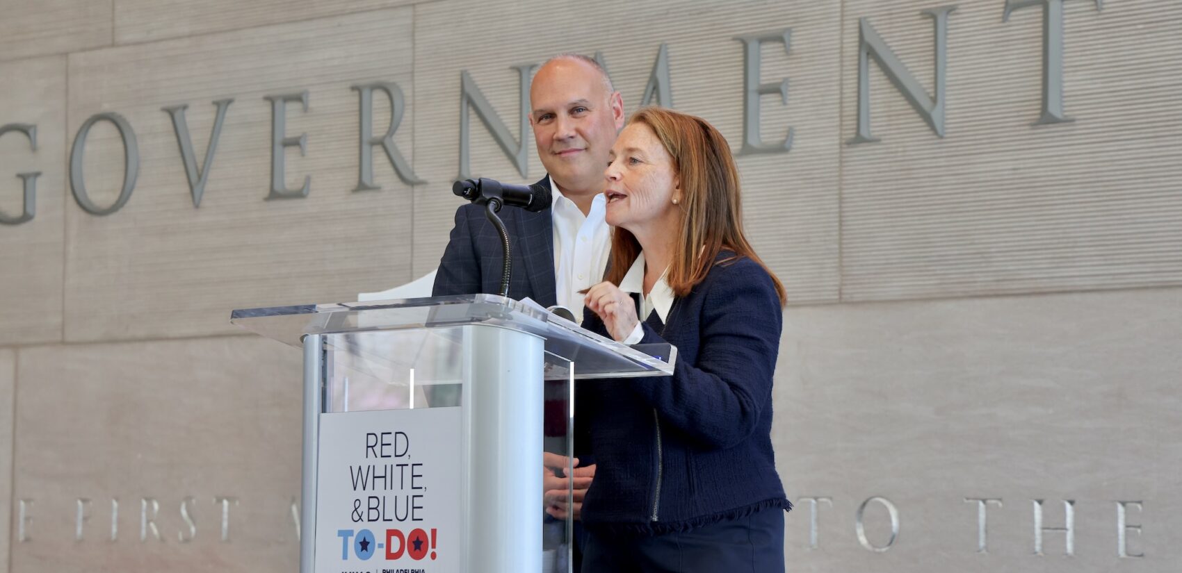 Amy Needle speaks behind a podium