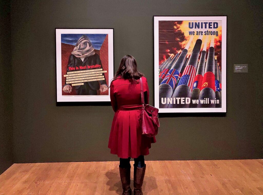 2025 04 10-p crimmins-philadelphia museum of art-boom art and design in the 1940s war posters A visitors look at two posters, one reading UNITED we are strong UNITED we will win and This is Nazi brutality