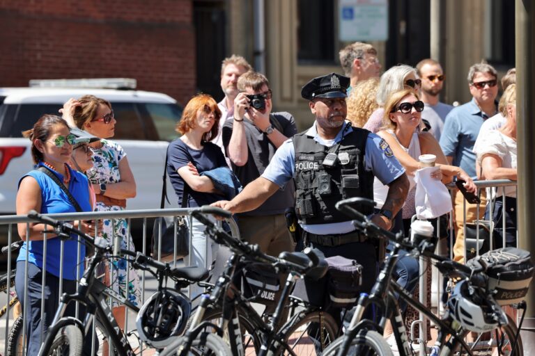 Passersby and a police officer at the Prince Edward event in Philadelphia
