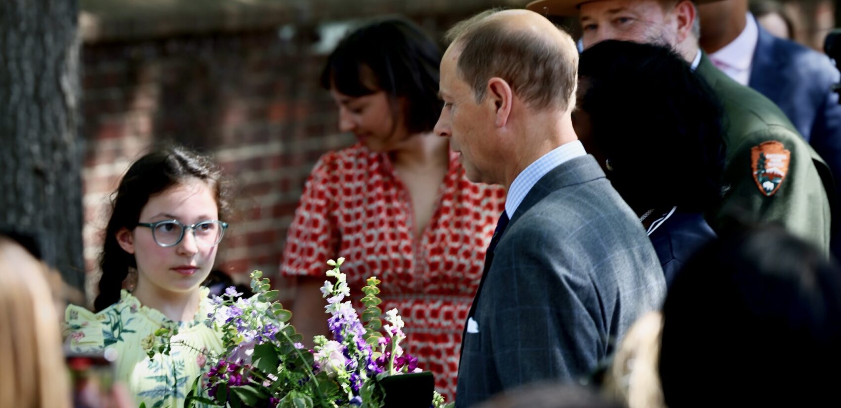 A girl presents a bouquet of flowers to Prince Edward at the Prince Edward event in Philadelphia