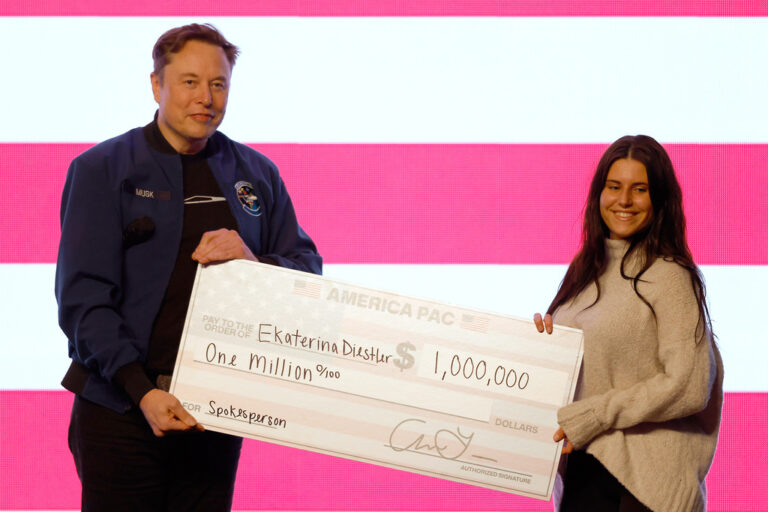 Elon Musk presents a woman with an oversized check for $1 million