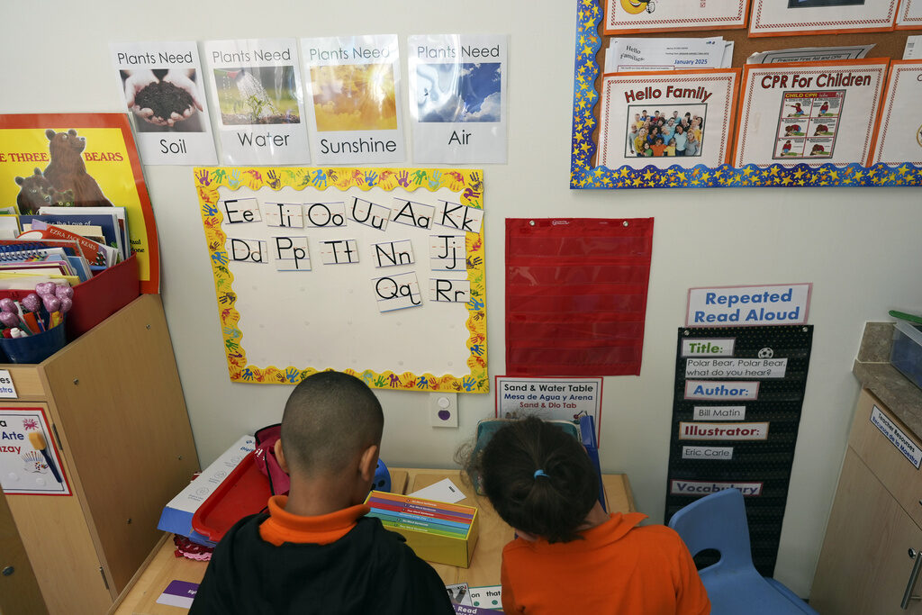 Health Department Head Start Education Two students help put away supplies in a classroom