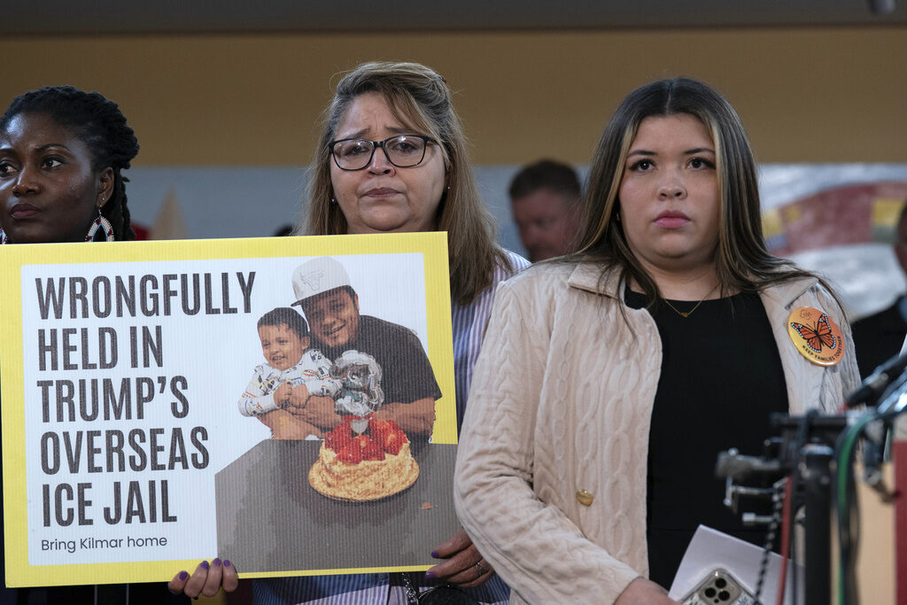 Maryland Deportation Error A woman stands with a sign that reads