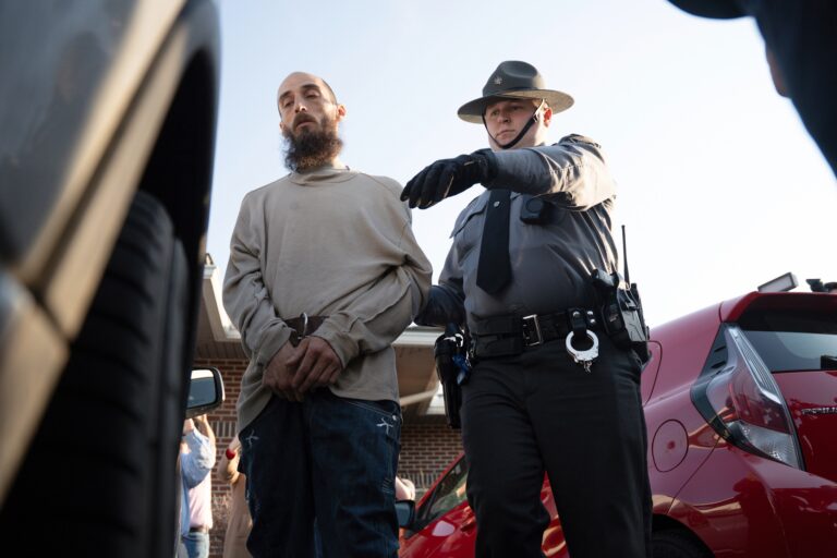 Cody Balmer escorted by an officer