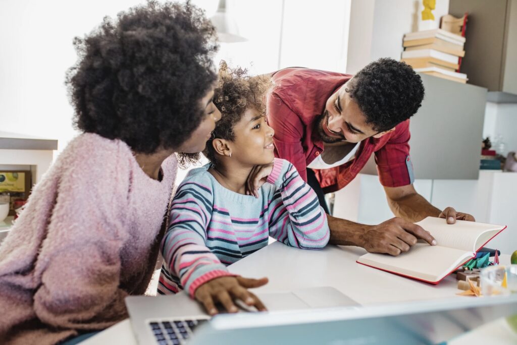 Parenting Two parents help their child for their homework.