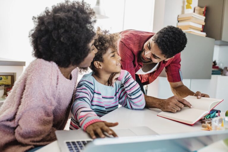Two parents help their child for their homework.