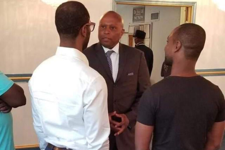 LuQman Abdullah speaks with two men