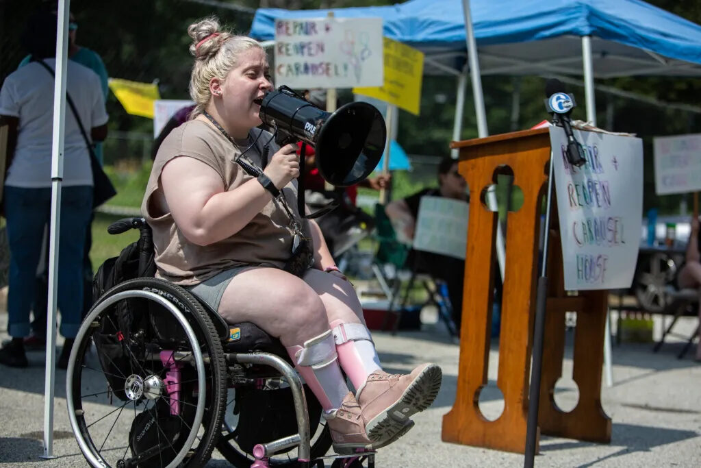 carouselhouse-protest16-scaled-2021 Natalie Kolander speaks into a megaphone