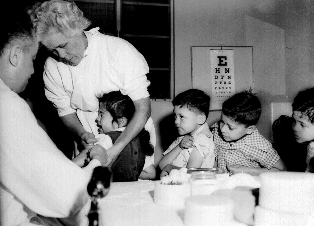 Children lining up to get a vaccine shot from the doctor