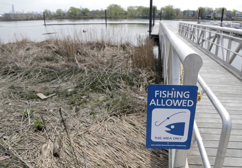 fishing-sign-new-jersey a sign by the water reads FISHING ALLOWED