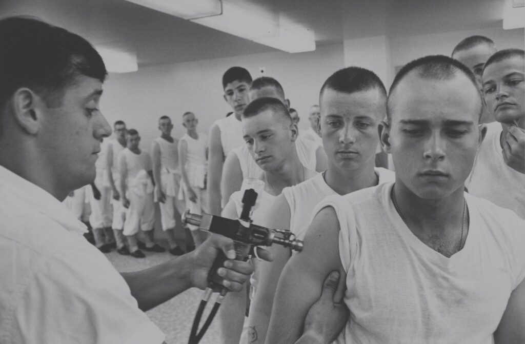 Navy recruits in 1965 wait in line for immunizations