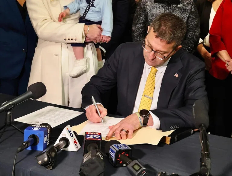 El gobernador de Delaware, Matt Meyer, firma su primera orden ejecutiva, creando un programa de formación profesional para jóvenes, detrás del escenario después de la ceremonia de toma de posesión en la Universidad Estatal de Delaware.