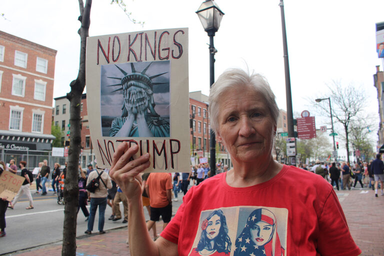 A woman holds up a sign reading 