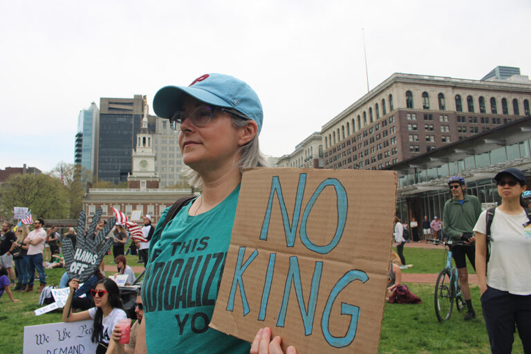 A woman holds a sign reading 